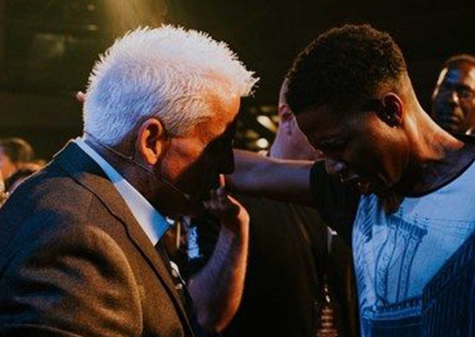 Robert Henderson praying for a man during a ministry event