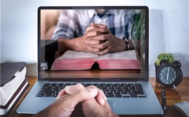 Person praying during Open Heaven AM Online Prayer Meeting via Zoom.